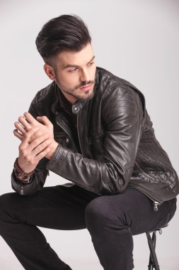 bir sandalyede oturan çekici genç moda adam