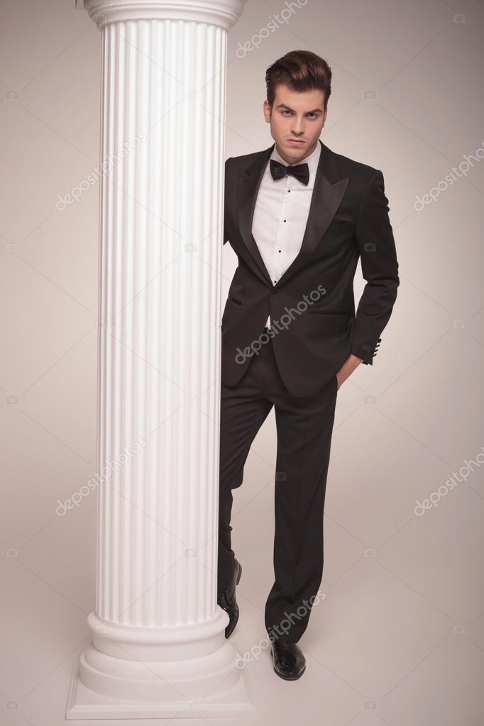 business man standing near a white column