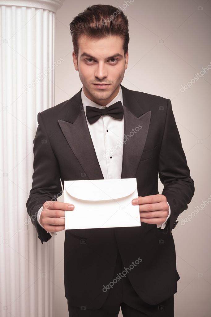 Handsome young business man giving you a white envelope.