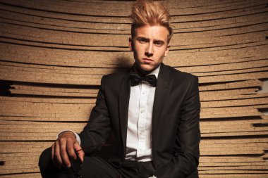 Young elegant business man posing on wood background