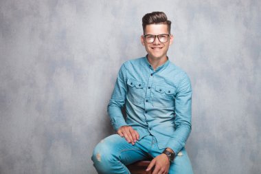 bir sandalyede oturan genç moda adam