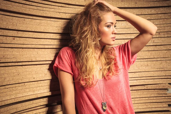 Vista laterale di una donna di moda cool tenendo i capelli e guarda — Foto Stock