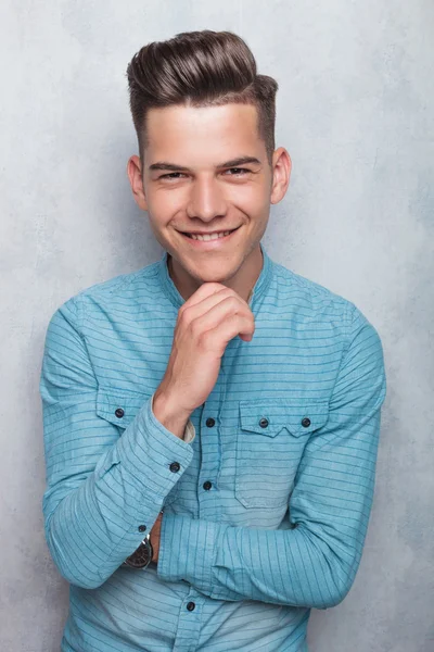 Happy young man holding his hand to the chin. — Stock fotografie