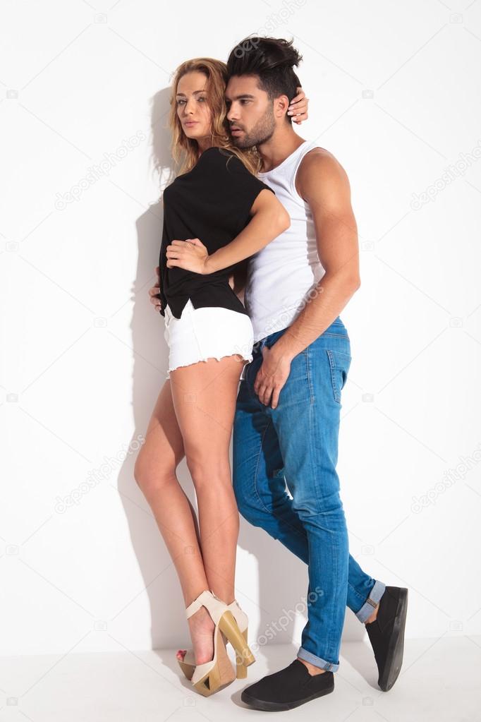 young fashion couple leaning on a wall.