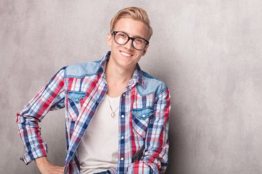 Kameraya gülümseyen yakışıklı sarışın adam.