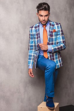 bir kutu üzerinde şeytanın bacağını tutarak ayakta iş adamı