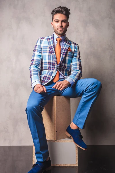 Модный бизнесмен, сидящий на деревянных коробках — стоковое фото
