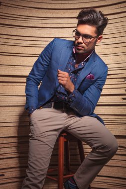 Bir sandalyede oturan çekici moda adam 