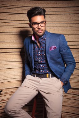 Yakışıklı genç moda adam bir sandalyeye yaslanmış 