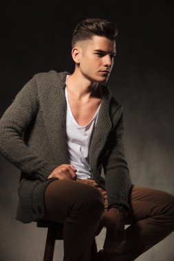 Dalgın genç adam bir sandalyede oturuyor 