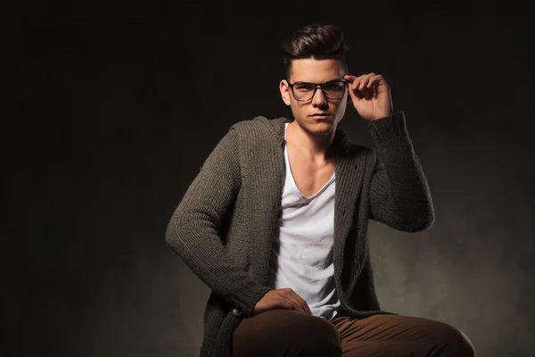 Handsome young man fixing his glasses. — Stock Photo, Image