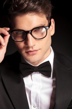 young handsome man fixing his glasses.