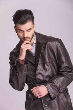 young business man holding his hand to the chin 