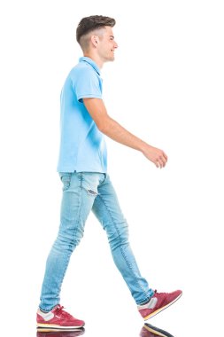  young casual man walking on isolated background.