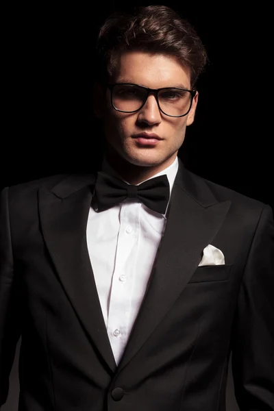 Elegant young man wearing a tuxedo and glasses. — Stockfoto