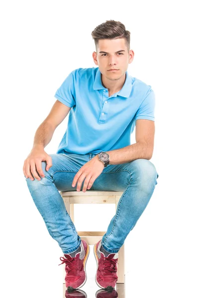 Pensive young man sitting on a chair — Stock Photo, Image