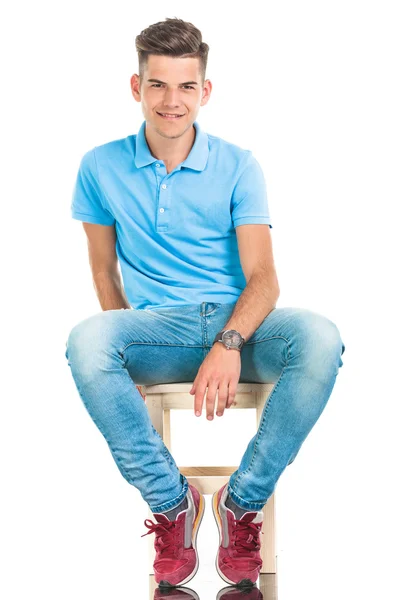 Joven hombre casual sentado en una silla . — Foto de Stock