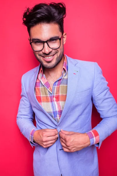 Smiling young man closing his jacket — Stockfoto