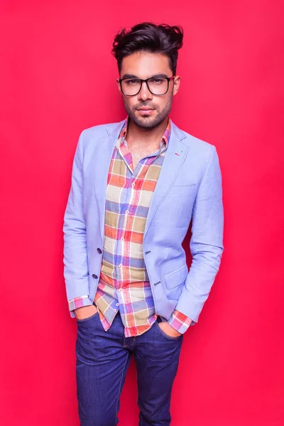 Young fashion man posing on red background — Stock Photo, Image