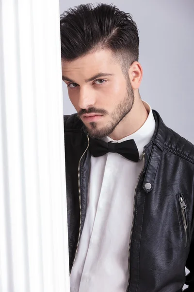 Young business man posing near a white column. — Stok fotoğraf