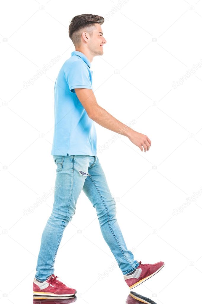  young casual man walking on isolated background.