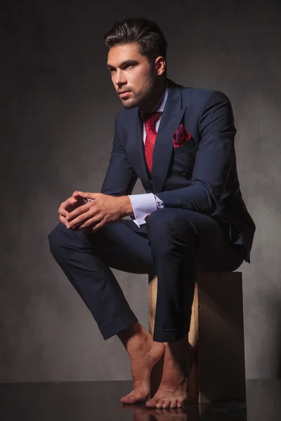 Pensive young business man sitting with his hands together — Stock Photo, Image