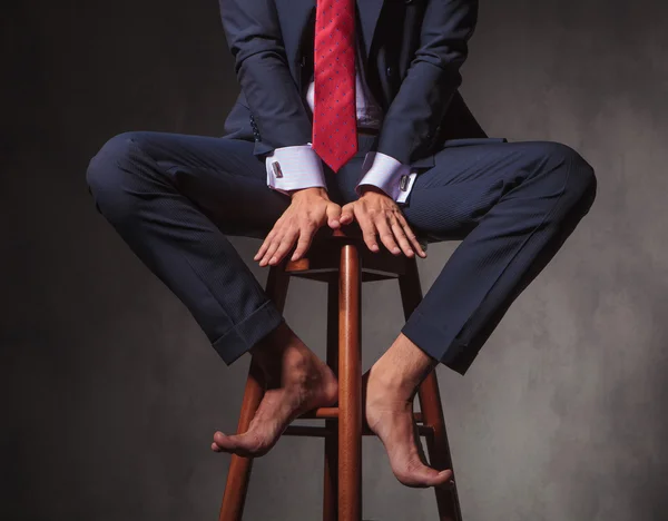 Barefoot business man sitting on a stool — Stock Photo, Image