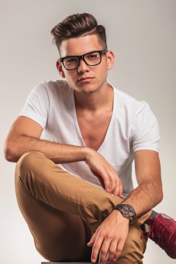 Akıllı adam bağdaş ile bir sandalyede oturan gözlüklü