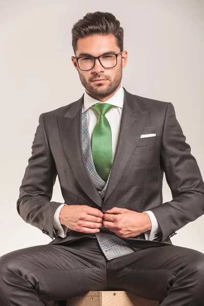 Business man closing his jacket while sitting. — Stockfoto