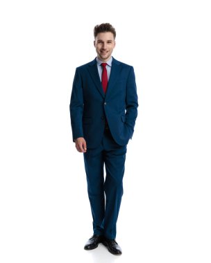 Lacivert takımlı mutlu genç adam el ele tutuşup gülümsüyor ve beyaz arka planın önünde duruyor.