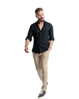 Gözlüklü havalı sakallı adam el ele yürüyor ve beyaz arka planda başka tarafa bakıyor.