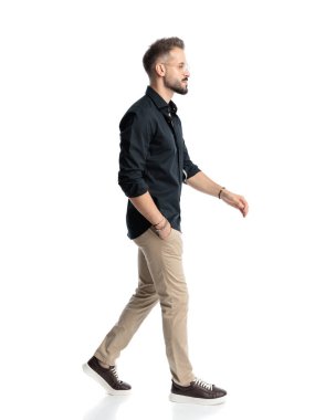 Yandan bakan, gözlüklü, el ele yürüyen ve beyaz arkaplanın önüne bakan seksi bir adam.