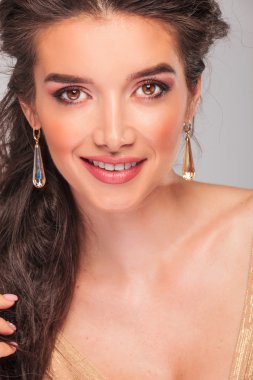 curly brunette smiling while looking at the camera