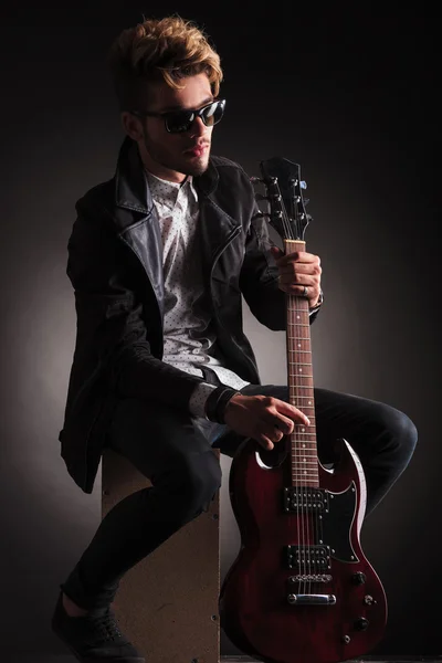 Seated guitarist poses for the camera — Stok fotoğraf