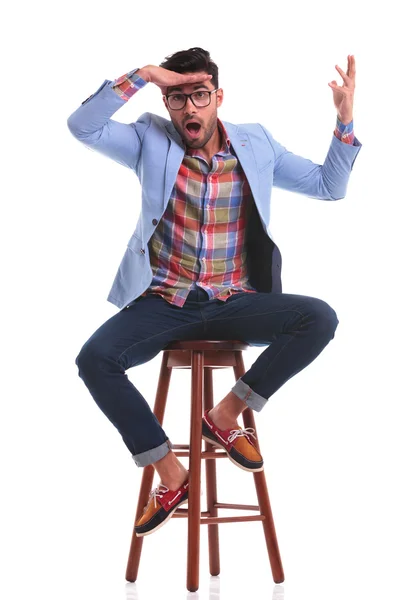 Příležitostné muž sedící přitom legrační obličej — Stock fotografie