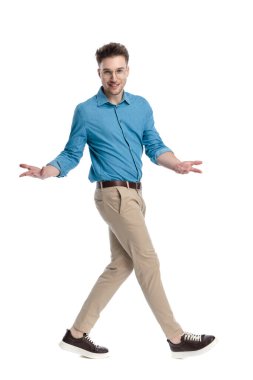 Gözlüklü, kolları açık, gülümseyen, beyaz arka planda soyutlanmış mutlu genç bir adam..