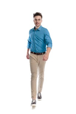 Gözlüklü mutlu genç adam ileri yürüyor ve gülümsüyor, beyaz arka planda soyutlanmış..