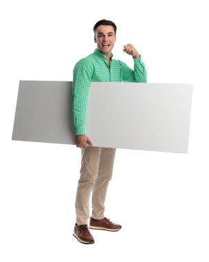 Heyecanlı sıradan bir adam, kolunun altında büyük boş bir tahta tutuyor ve zaferi kutlamak için bir yumruk kaldırıyor.