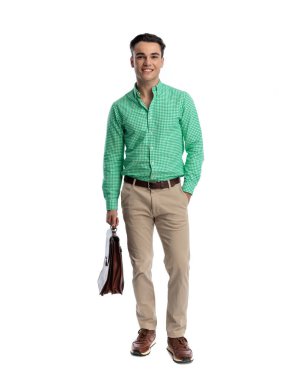 Cebinde el ele duran ve beyaz arka planda ileriye bakan bir evrak çantası tutan mutlu genç işadamı.