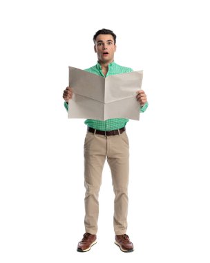 Şok olmuş sıradan bir adam boş bir gazeteyle beyaz arka planda bekliyor.