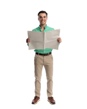 Neşeli, sıradan bir adam elinde açık bir gazete tutarken beyaz arka planda ileriye bakıyor.