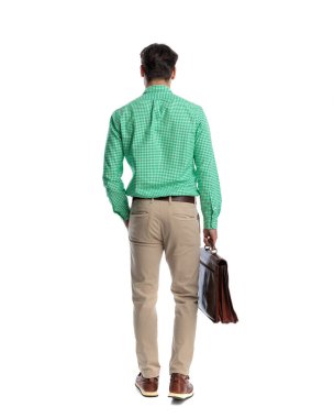 Bir eli cebinde, beyaz arka planda izole edilmiş bir evrak çantası tutan sıradan bir adamın arka planı.