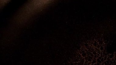 Koyu altın boya dalgalarının soyut makro çekimi, hafif aydınlatılmış mikro ayrışma hücresel şekiller, ipeksi doku gösterimi.