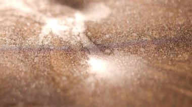 Işığın ince yatay hareketine odaklanan ve yüksek desenli altın yüzey boyunca uzanan gölge çizgilerine yakın plan altın rengi boya..