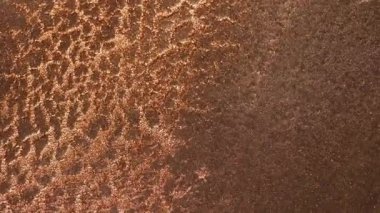 Uzmanlaşılmış altın boyanın zaman atlamalı karmaşık, çatırdayan, perdeli dokunun yüzey boyunca uzanan karmaşık ve hassas bir kalıbını ortaya çıkarıyor..