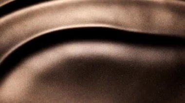 Büyük dalgaların ve derin tepelerin soyut yavaş çekim videosu. Koyu sarı sıvı boya ve ışık ve gölgelerin dramatik varyasyonları tarafından yaratıldı..