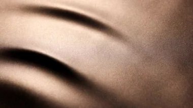 Koyu altın yüzey boyunca zarif, ritmik hareketler, yumuşak, yavaş dalgalanmalar ve kayan ipek kumaşa benzeyen büyük dalga desenleri oluşturur..