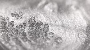 Özel kumlu desenli gümüş titanyum boyanın detaylı yakın plan görüntüsü karmaşık hücresel desenlere ayrılarak ışıl ışıl parçacıklardan ve sıvı hareketten oluşan perdeli bir yapıyı ortaya çıkarıyor.