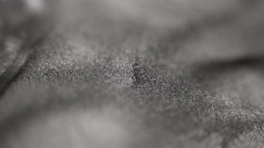 Ağır dalgaları ve tepeleri kaplayan özel kumlu desenli statik gümüş titanyum boya ile soyut makro video ışıl ışıldayan parçacıklar ışıkta kayar ve siyah arkaplanda derin bir kontrastı ortaya çıkarır.
