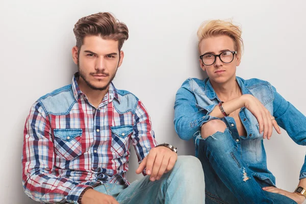 Sentados jovens homens casuais olhando para a câmera — Fotografia de Stock